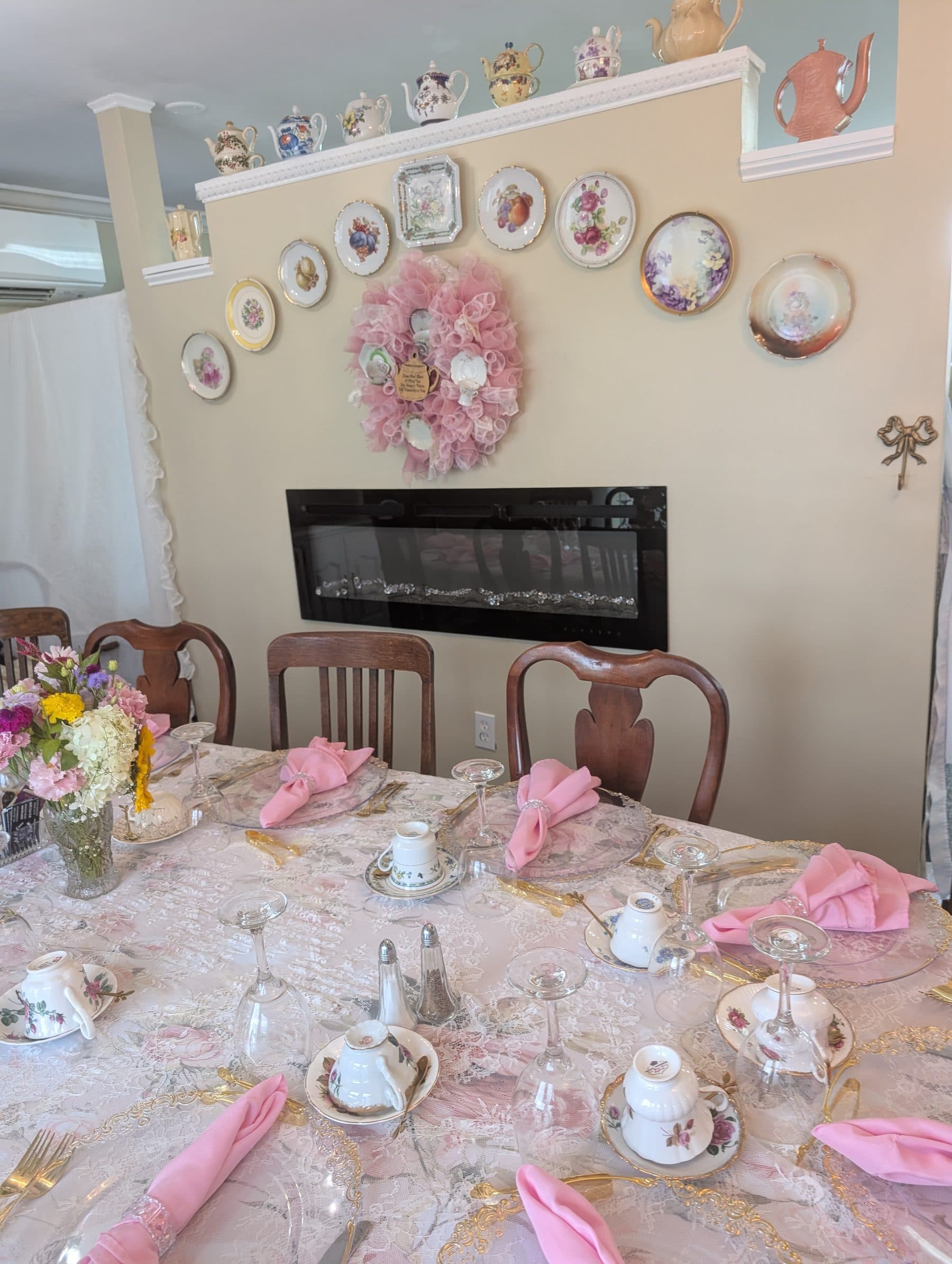 Painted china plates hung above the fireplace with teapots along the shelf